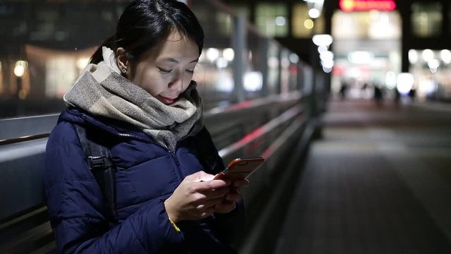 Woman use of cellphone in street of Tokyo at night