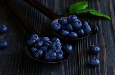 Ripe blueberries on a dark wooden background. Low key.Close up