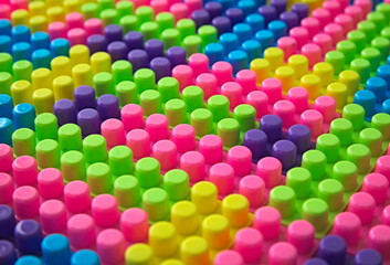 A colorful repeating pattern formed from toy building blocks.