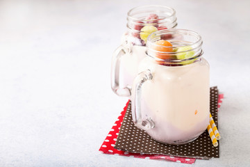 Yogurt and the frozen fruit in glasses on a light background. Selective focus. Copy space