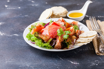Healthy food - vegetables and salmon salad on a dark background. Selective focus. Copy space