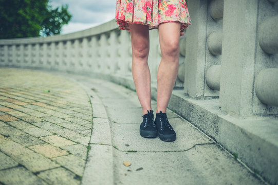 Legs of young woman by wall in city