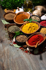 assortment of oriental spices on a wooden table, vertical