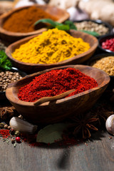 assortment of spices and herbs on a wooden table, closeup