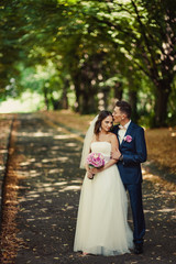Naklejka premium Beautiful bride and groom embracing and kissing on their wedding day