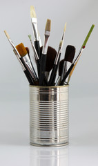 Different paintbrushes in a bucket