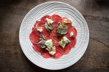 Beef carpaccio with  sauce on white plate
