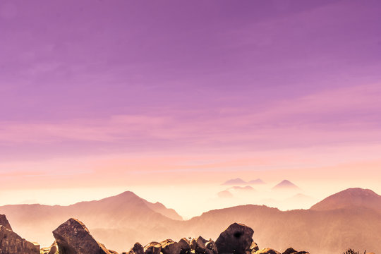 View of violet sunset over foggy volcanoes of Lago Atilan