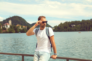 Tourist man sitting on the lake and enjoying the view.