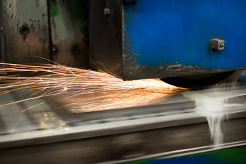 Work of an industrial surface grinding machine. Grinding of a flat metal part.