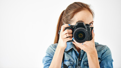 Portrait of a girl photographer on a white background