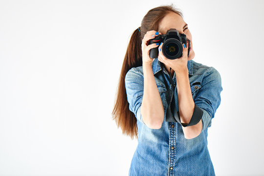 Portrait of a girl photographer on a white background