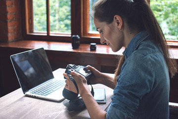 Portrait of a girl photographer working with a computer