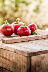 Fresh sweet red pepper on old wooden background.