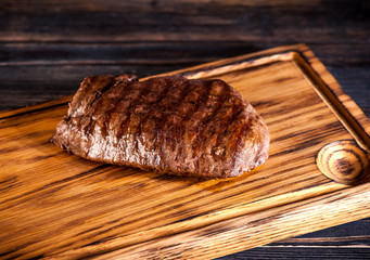 Medium rare grilled Steak Ribeye on a wooden board