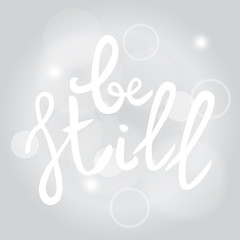 Be still Lettering phrase. Hand drawn motivation and inspiration quote. White letters on gray blured background. Artistic design element for poster, banner. Calligraphy print. Vector illustration.