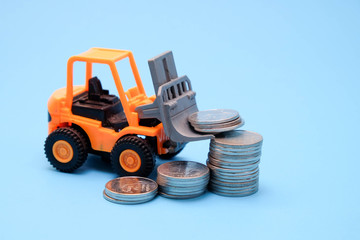 save money for investment concept truck toy and Coins on blue background