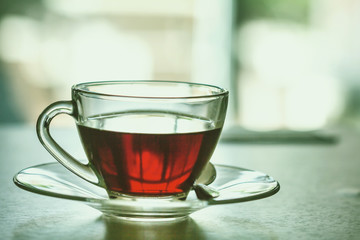 Close up the warm black tea cup on the wooden table in living room , relax with tea time concept