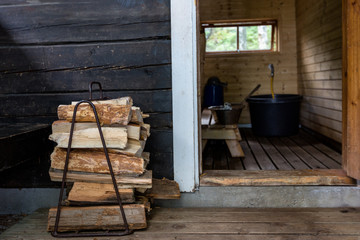 Firewood next to the open door to the traditional Finnish sauna