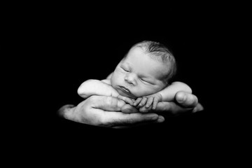 Beautiful baby boy, sleeping peacefully in fathers hands, infant sleeping