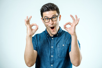 Handsome man in jeans shirt showing ok sign