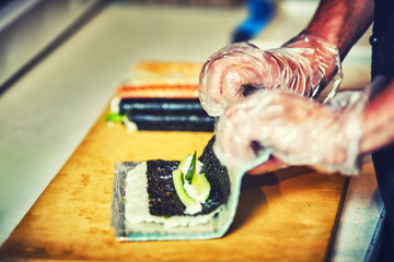 chef prepares sushi at the restaurant .
