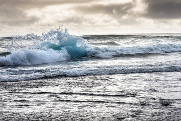 Angeschwemmter Eisberg in den Wellen am Black Diamond Beach in Südisland