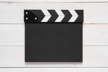 Fototapeta premium blank black clapper board on top view vintage white wood table for the action scene or filming and shooting movie or cinema production
