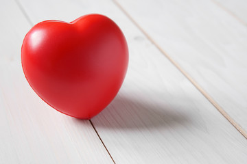 closeup red heart rubber on the vintage white wood table for love memorial or romantic on Valentine day and heart health with space