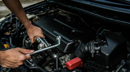 Hand of mechanic is repairing car engine