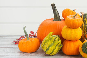pile of orange pumpkins on white wooden table