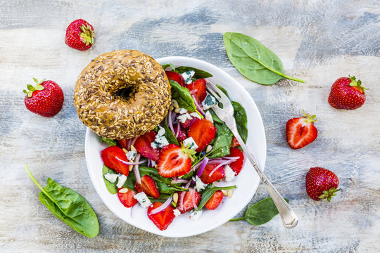 Delicious and healthy strawberry salad and spinach with bagels. 