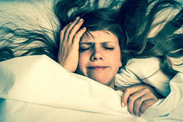 Woman in bed having headache in the morning