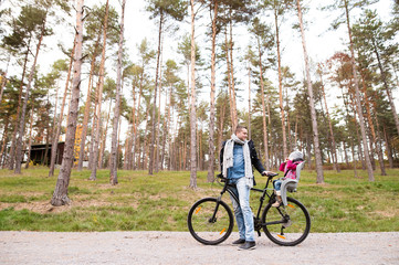 Obraz premium Young father and daughter together on bicycle in autumn park