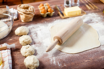 Rolled out dough on wooden table with rolling pin