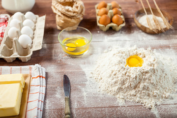 Egg yolk in flour on a wooden table in a bakery. Rural or rustic style.