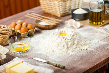 Egg yolk in flour on a wooden table in a bakery. Rural or rustic style.