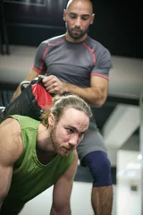 Gordijnen Adult men doing weightlifting in gym. Two men in the gym. © liderina
