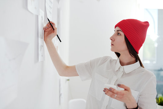 Young woman working on analitical reports and the phone