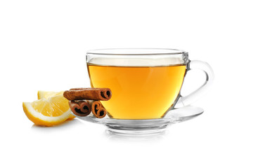 Cup of aromatic hot tea with cinnamon and lemon on white background