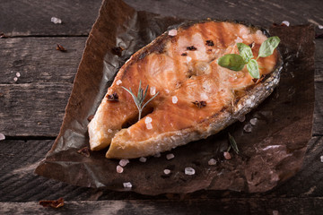 Grilled salmon on cutting board on wooden background