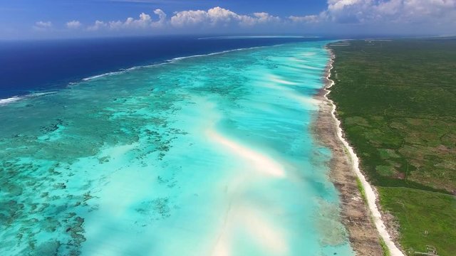 Aerial view of Nungwi, multicolored sea water of blue lagoon, north part of Zanzibar, White beach, Palm paradise, Tanzania from above, Africa, Indian Ocean, 4k UHD