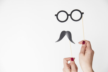 female hand holding glasses and mustache photo booth prop