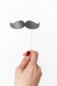 female hand holding mustache photo booth prop