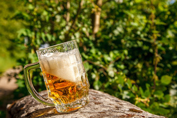 glass mug with beer standing on the big stone