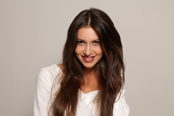 Fototapeta premium seductive and smiling young woman on a gray background