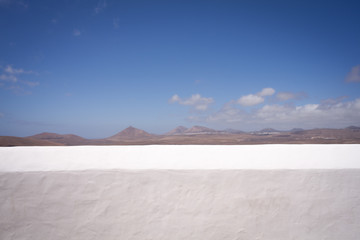 Lanzarote view over a white typical wall. landscape
