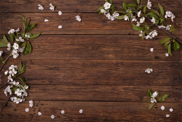 Obraz premium Wiosenne kwiaty. Gałęzie kwitnącej wiśni na brązowym stole.