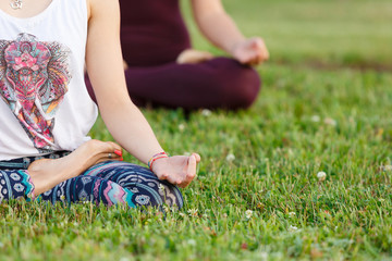 Yoga group concept. Young couple meditating together, sitting back to back on windows background, copy space