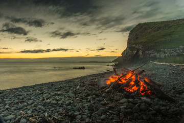 Long exposure of sunset at beach with fire